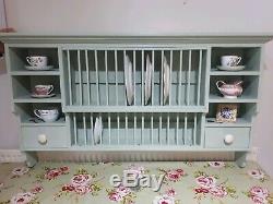 Wall mounted wooden plate rack painted in laurel green and finished with a wax