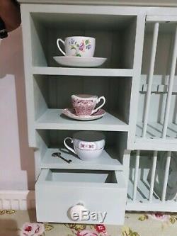 Wall mounted wooden plate rack painted in laurel green and finished with a wax
